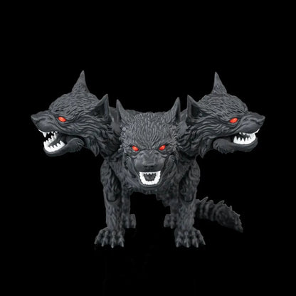 Top view of the three-headed black wolf facing towards glowing red eyes, sharp white teeth, and metallic silver claws, posed against a solid black reflective background.