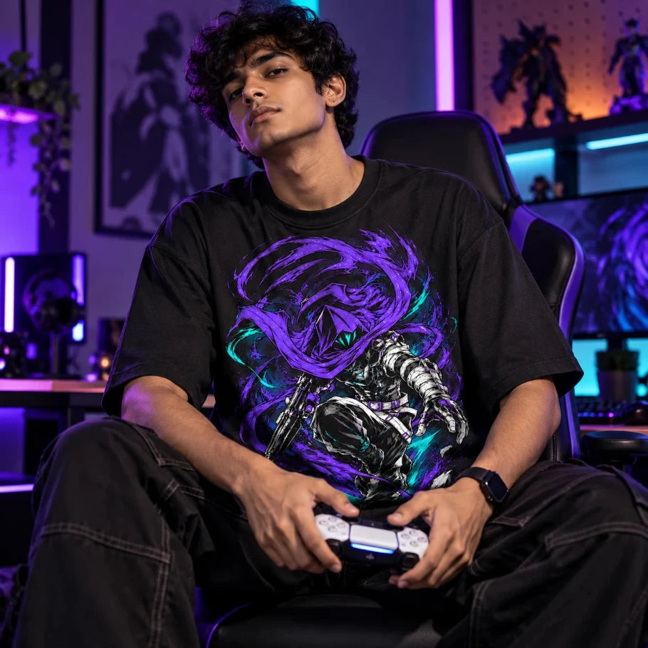 Young Indian gamer wearing black oversized anime graphic T-shirt while holding a gaming controller