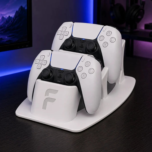 Two gaming controllers on a charging stand with a blurred gaming setup in the background