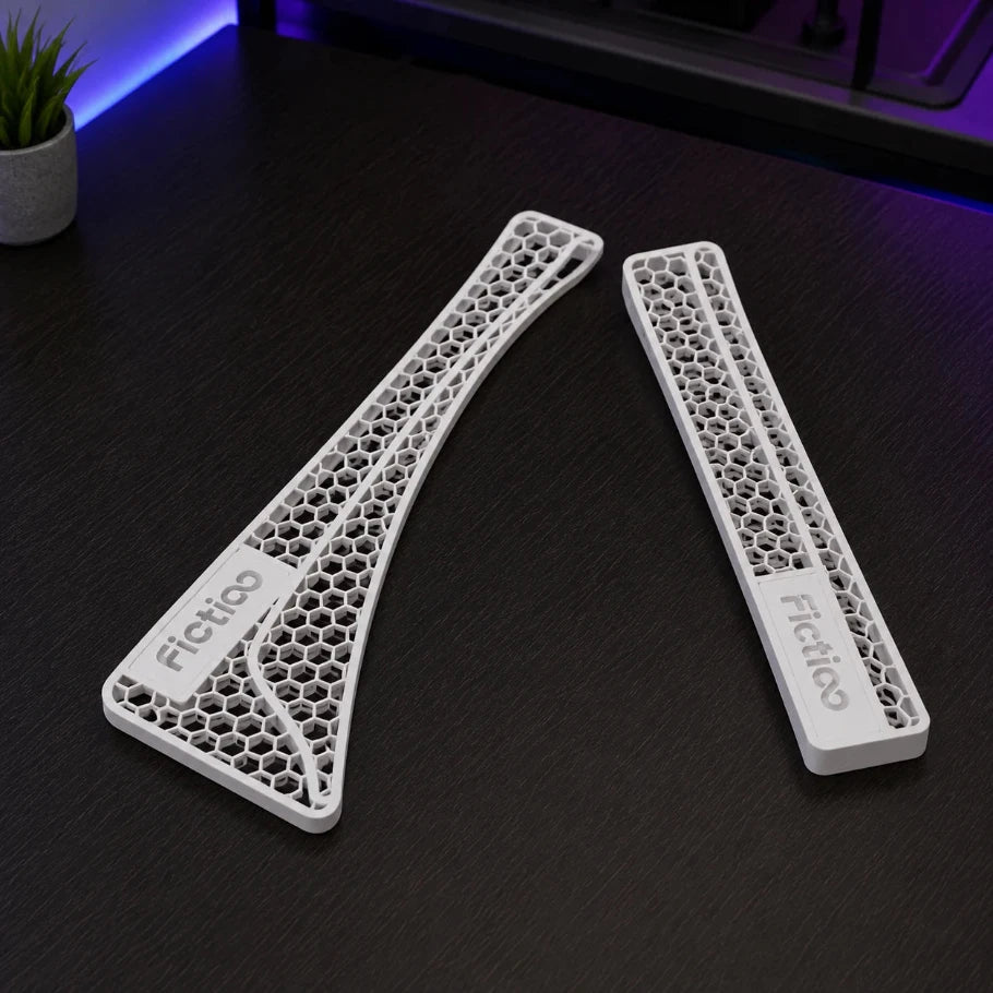 Two 3D-printed components with honeycomb structure on a dark surface, branded 'Fictiglo'.