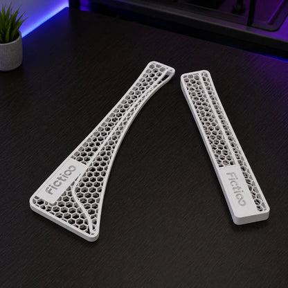 Two 3D-printed components with honeycomb structure on a dark surface, branded 'Fictiglo'.