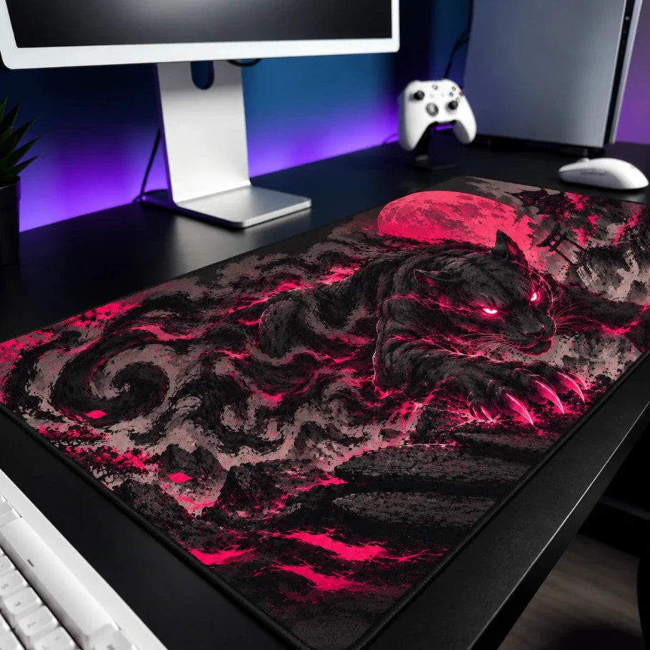 a large gaming desk mat with a dark wolf and red moon design, shown on a black desk with a keyboard, mouse, and monitor in a gaming setup.