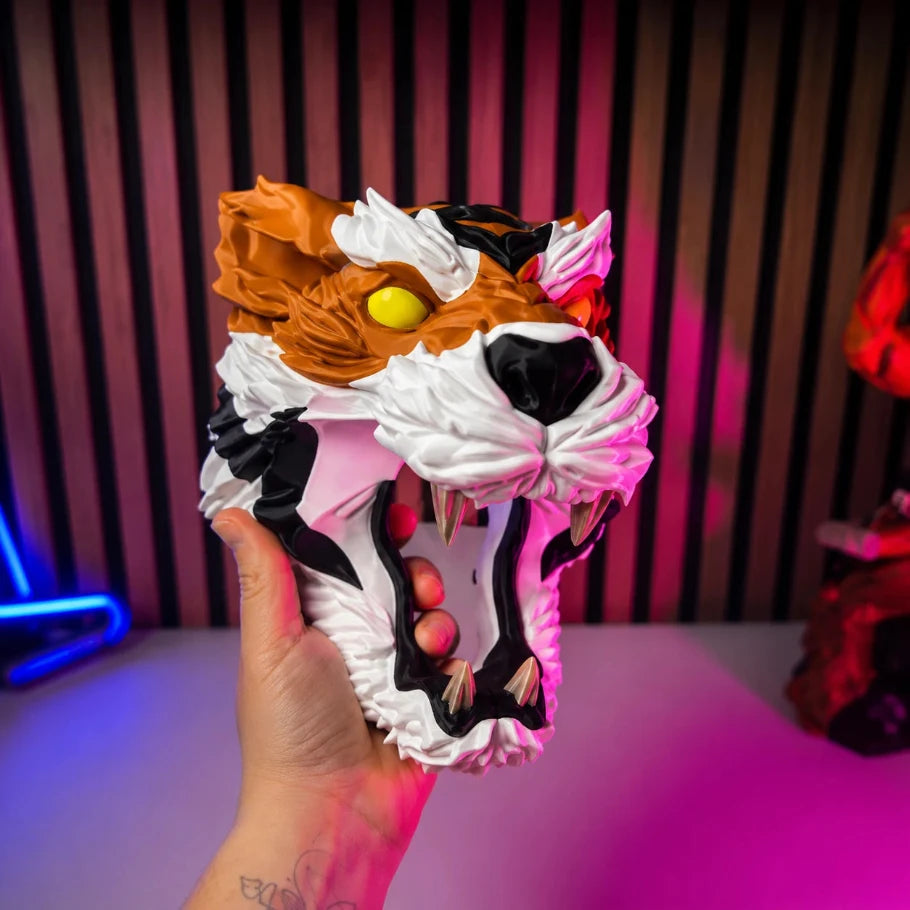 Hand holding a colorful mask with a stylized design against a vibrant background