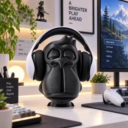 Zen Gorilla headphone stand on a white gaming desk holding white over-ear headphones, with a monitor, controller and keyboard in the background