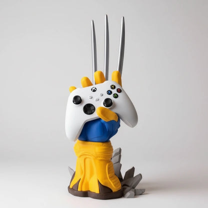 A collectible figurine of Wolverine holding a white Xbox controller, standing on a wooden tabletop with a potted plant in the background.