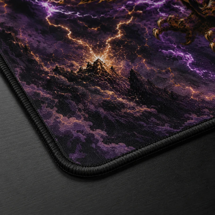 a close-up of a gaming mouse pad showing its corner, featuring a fantasy landscape print with purple clouds, lightning, and a glowing mountain on a dark surface.
