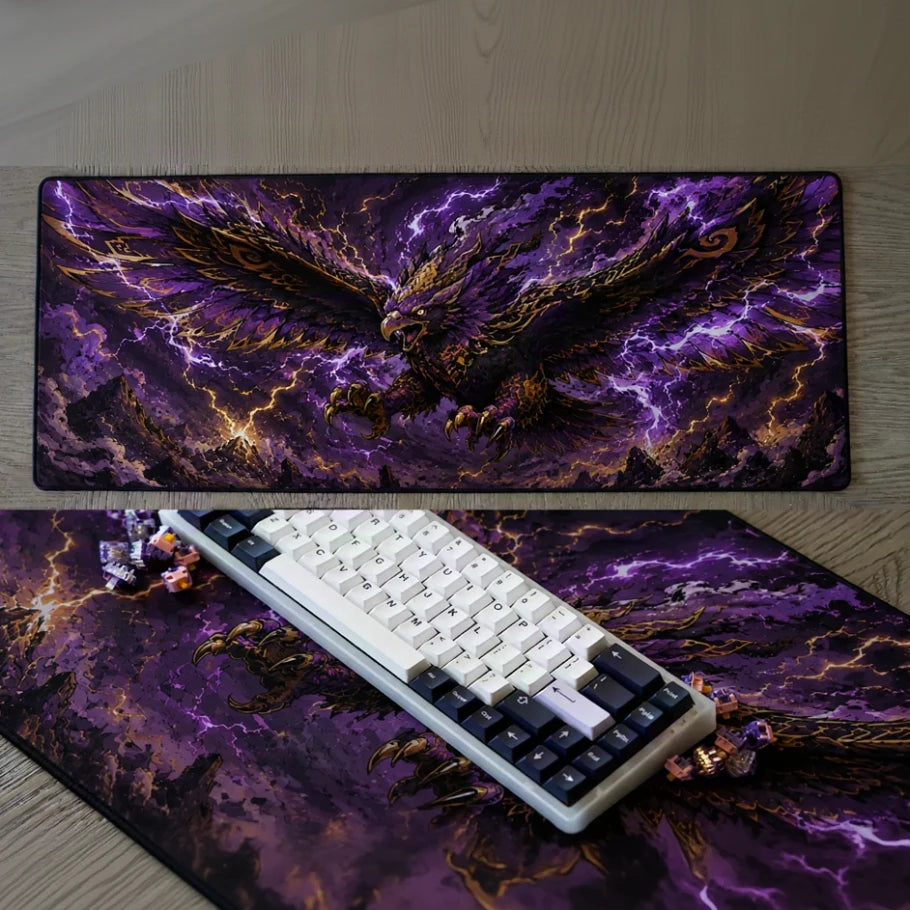 a large rectangular desk mat with a dramatic fantasy print of a golden eagle or phoenix surrounded by purple lightning, shown on a wood surface with a keyboard placed on top.